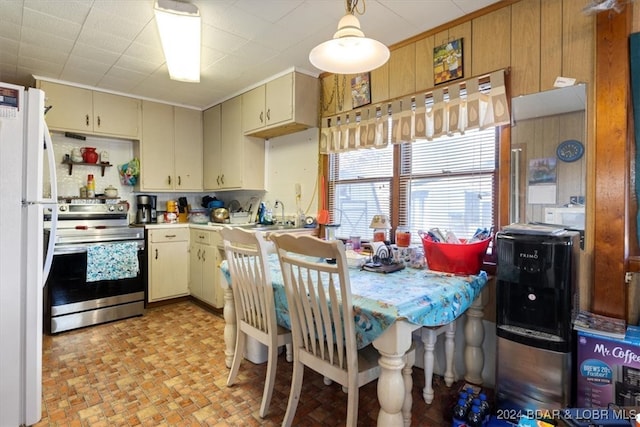 kitchen with stainless steel range, hanging light fixtures, cream cabinetry, and white refrigerator