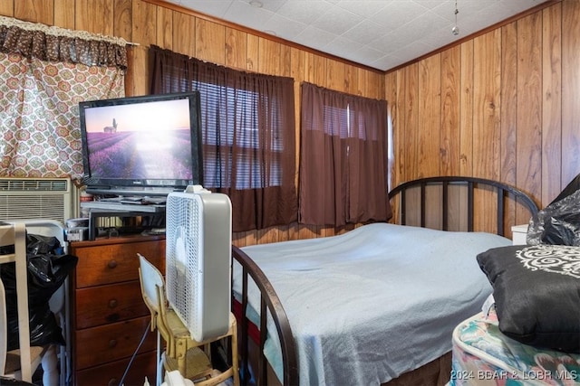 bedroom featuring crown molding and wooden walls