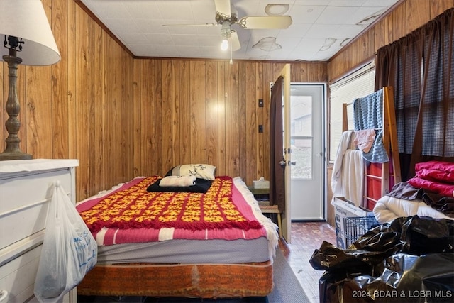 bedroom featuring wooden walls and ceiling fan