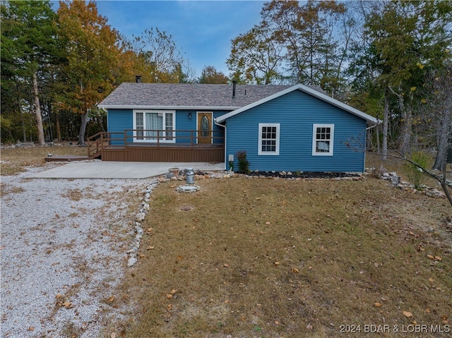 view of front of home with a front yard and a wooden deck