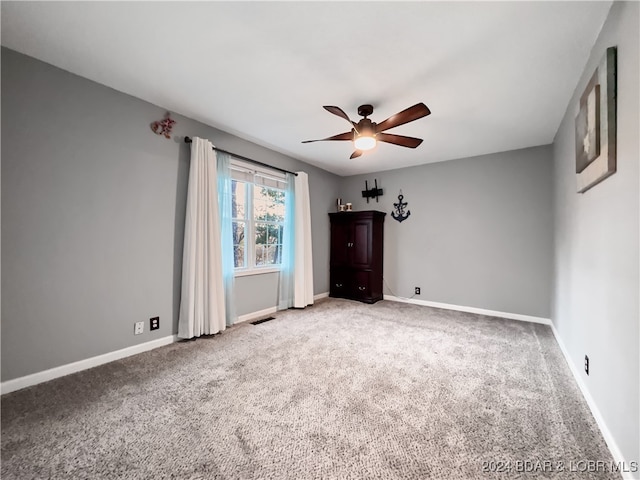 carpeted spare room featuring ceiling fan