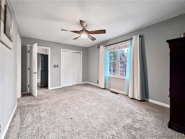 unfurnished bedroom featuring a closet, ceiling fan, and light carpet