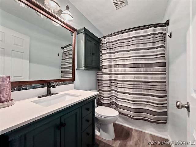 full bathroom featuring vanity, toilet, shower / tub combo, and hardwood / wood-style floors