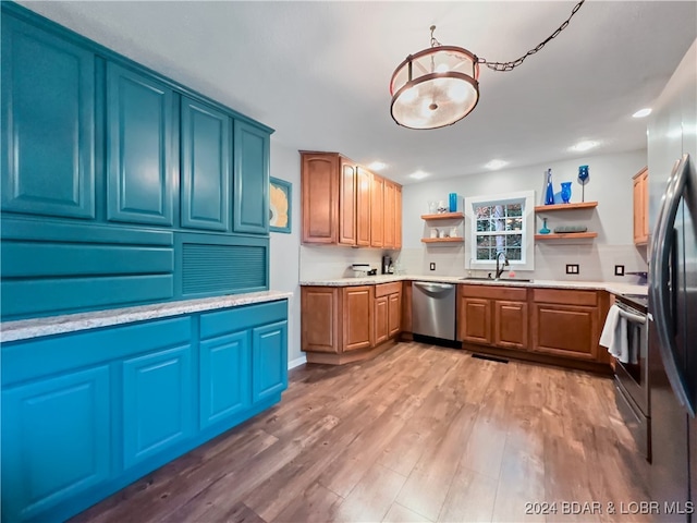 kitchen featuring stainless steel appliances, sink, and light wood-type flooring