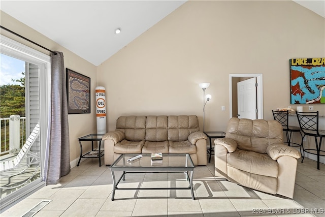 living room featuring high vaulted ceiling and light tile patterned floors