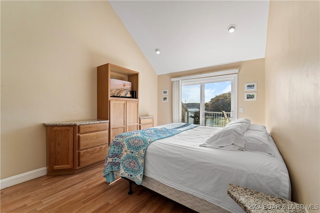 bedroom with high vaulted ceiling, wood-type flooring, and access to outside