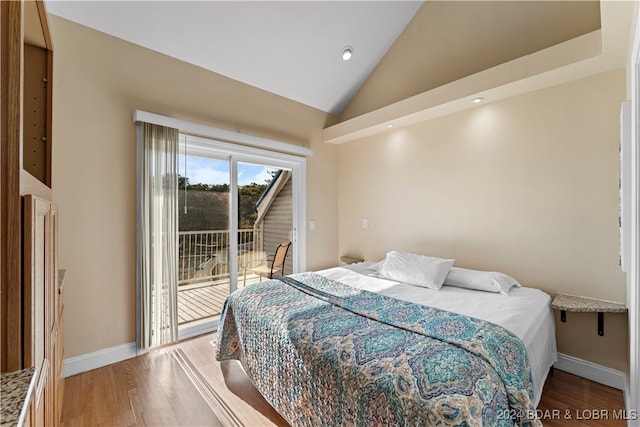 bedroom with access to outside, hardwood / wood-style floors, and high vaulted ceiling