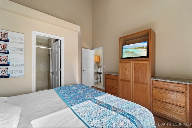 bedroom with ensuite bathroom and a high ceiling