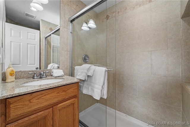 bathroom featuring vanity and an enclosed shower