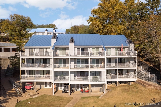 back of house with a yard, a patio area, and a balcony