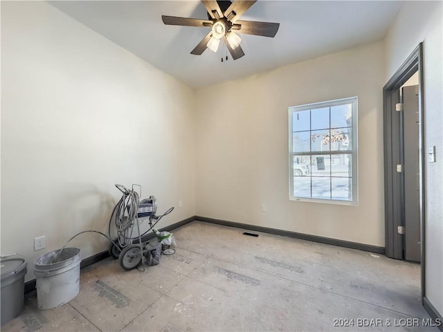 unfurnished room featuring a ceiling fan and baseboards