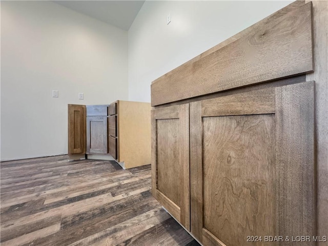 corridor featuring dark wood-style floors and a high ceiling