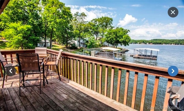 wooden deck featuring a boat dock and a water view