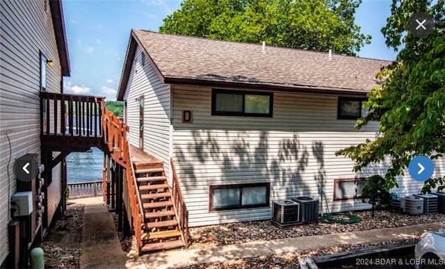 back of property featuring a wooden deck and cooling unit