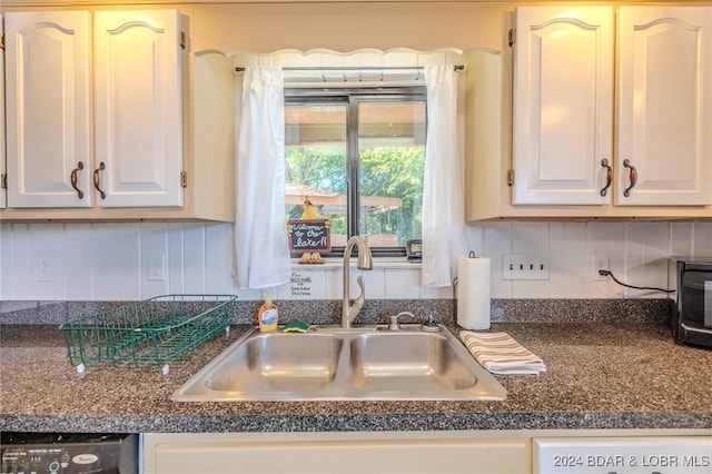 kitchen featuring decorative backsplash, white cabinetry, and sink