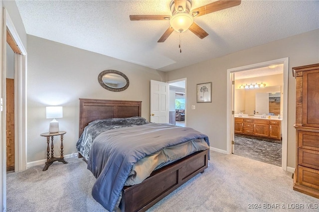 carpeted bedroom featuring a textured ceiling, connected bathroom, ceiling fan, and sink