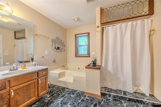 bathroom with a tub to relax in, vanity, and a textured ceiling