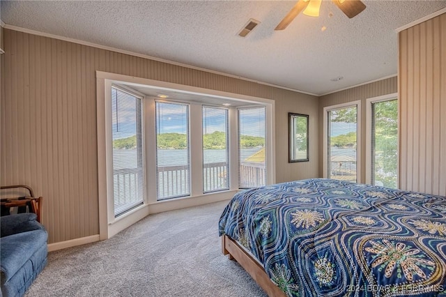 carpeted bedroom featuring access to exterior, visible vents, multiple windows, and ornamental molding