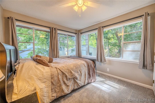 bedroom with carpet, ceiling fan, and a textured ceiling