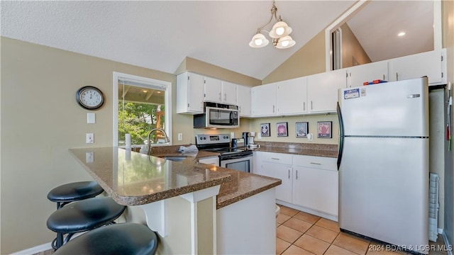 63 Elbow Cay Dr, Osage Beach, MO 65065 - kitchen featuring stainless steel appliances, a sink, a peninsula, white cabinets, and lofted ceiling