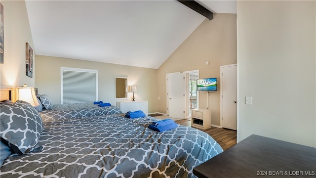 bedroom with beamed ceiling, hardwood / wood-style flooring, and high vaulted ceiling