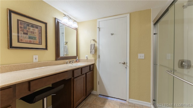 bathroom featuring vanity, a textured ceiling, and an enclosed shower