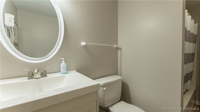 bathroom featuring vanity, a shower with curtain, and toilet