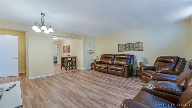 living room featuring a chandelier and light wood-type flooring