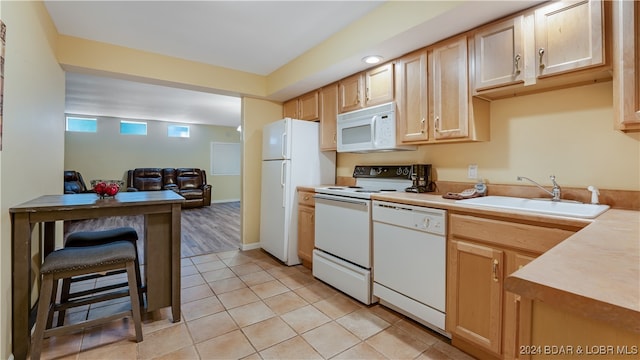 kitchen featuring light brown cabinets, sink, light tile patterned floors, and white appliances