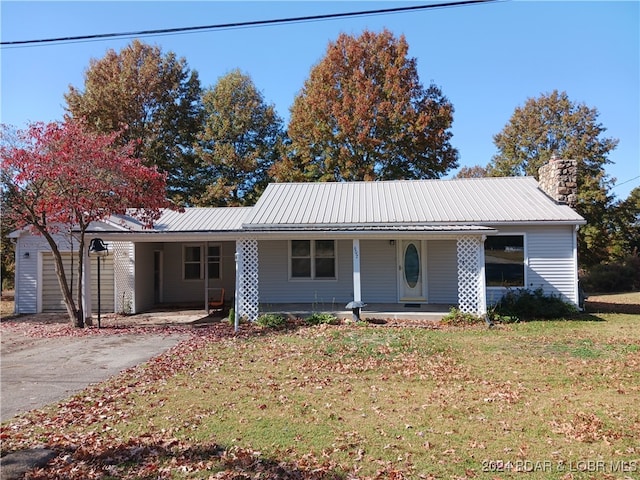 ranch-style home with covered porch, a front lawn, and a carport