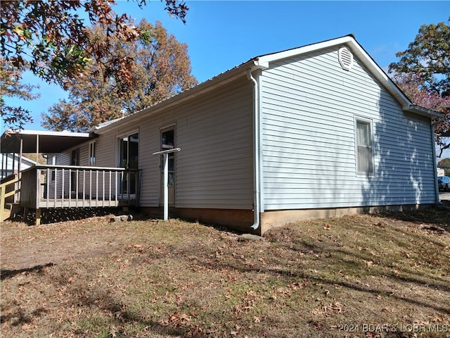 view of property exterior with a yard and a wooden deck