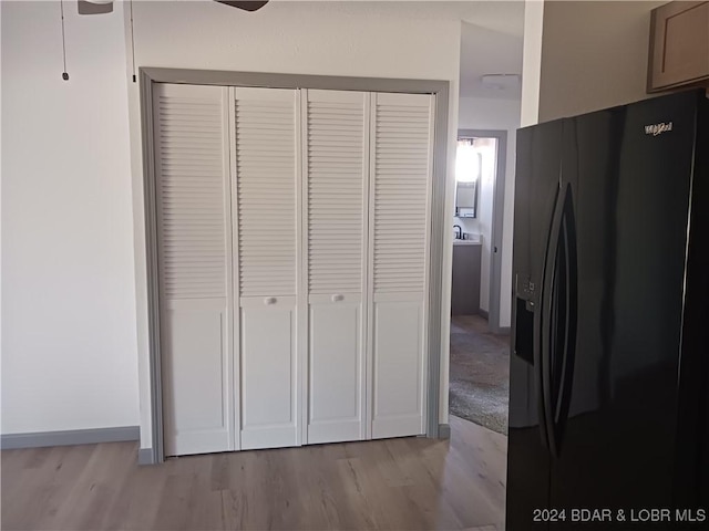 607 N Hughes Ave, Stover, MO 65078 - detailed view of black refrigerator with ice dispenser, wood finished floors, ceiling fan, and baseboards