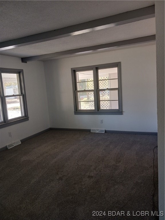 carpeted spare room with beamed ceiling and a textured ceiling