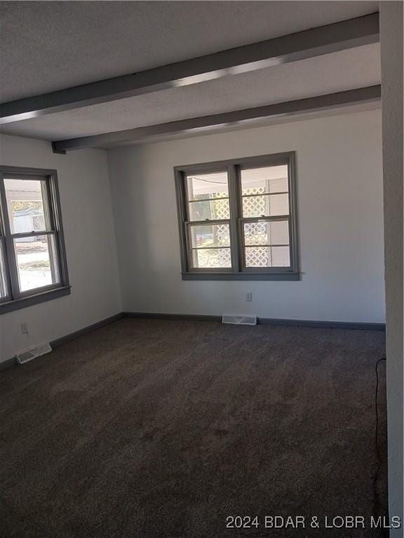 607 N Hughes Ave, Stover, MO 65078 - unfurnished room with dark colored carpet, beam ceiling, and baseboards