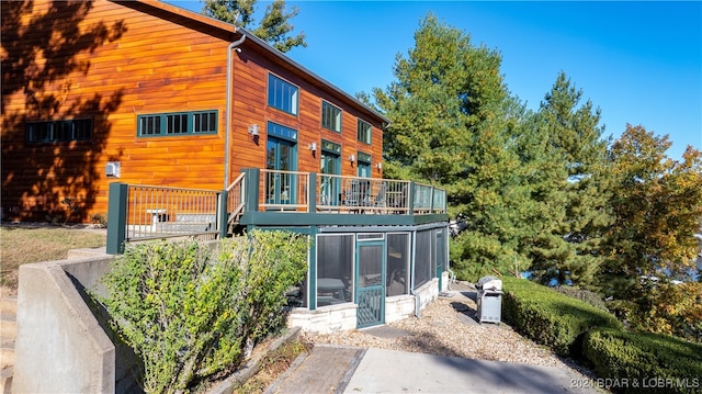 rear view of property featuring a sunroom