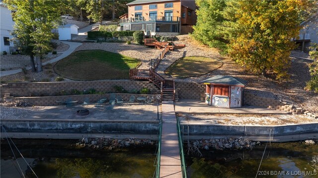 rear view of house featuring a deck with water view