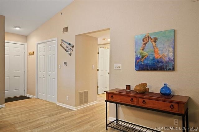 611 Lazy Days Rd Unit X11, Osage Beach, MO 65065 - corridor featuring baseboards, visible vents, vaulted ceiling, and light wood finished floors
