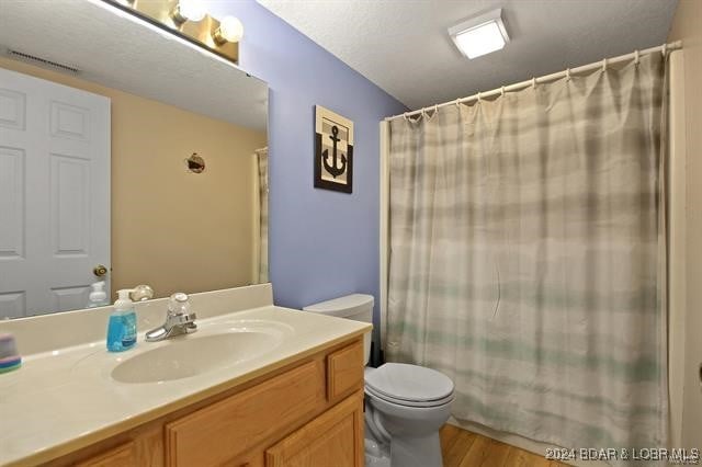 611 Lazy Days Rd Unit X11, Osage Beach, MO 65065 - bathroom featuring a shower with curtain, visible vents, wood finished floors, vanity, and toilet