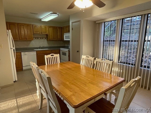 tiled dining space with ceiling fan and sink