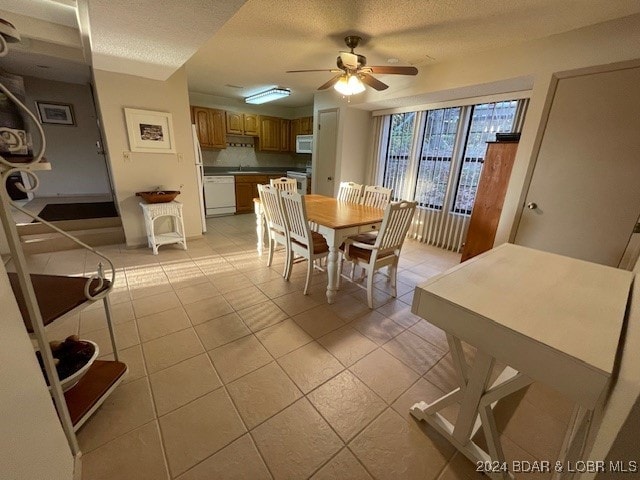 dining room featuring ceiling fan, a textured ceiling, and light tile patterned floors