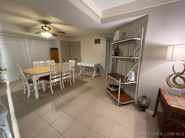 dining room featuring ceiling fan, a textured ceiling, and light tile patterned flooring