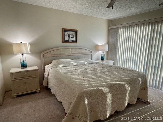 bedroom featuring a textured ceiling, carpet flooring, and ceiling fan