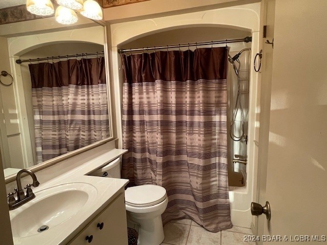 full bathroom with vanity, shower / bath combination with curtain, toilet, and tile patterned floors