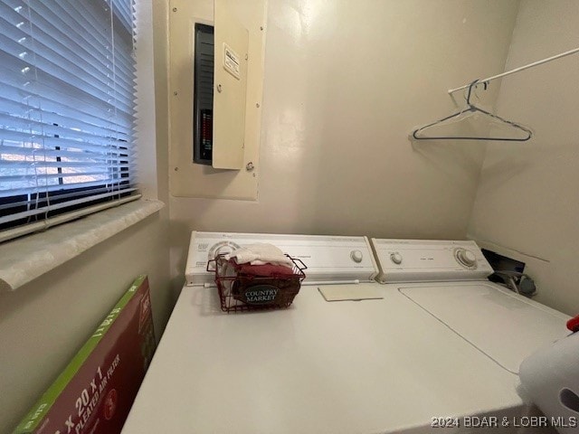 laundry room featuring electric panel and separate washer and dryer