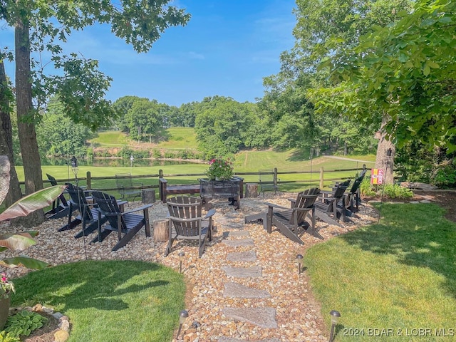 view of yard with an outdoor fire pit and a rural view