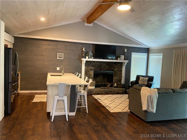 living room featuring sink, a fireplace, wood ceiling, lofted ceiling with beams, and dark hardwood / wood-style flooring