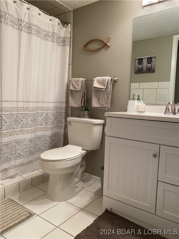 bathroom with a textured ceiling, walk in shower, toilet, vanity, and tile patterned flooring