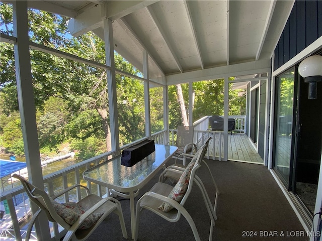 unfurnished sunroom featuring vaulted ceiling and a healthy amount of sunlight