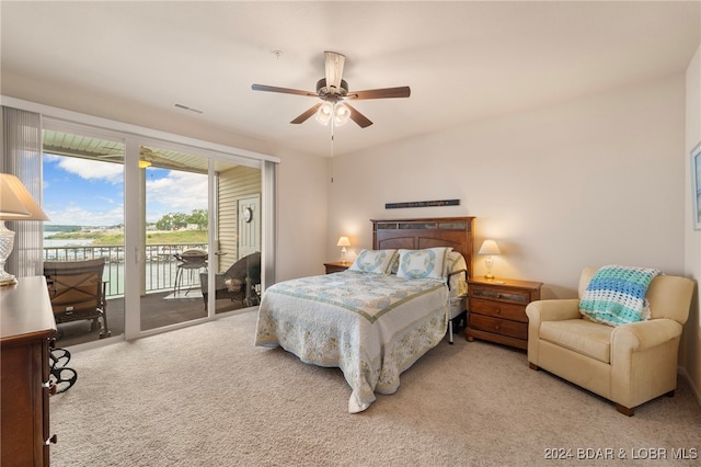 bedroom featuring light carpet, access to outside, ceiling fan, and a water view