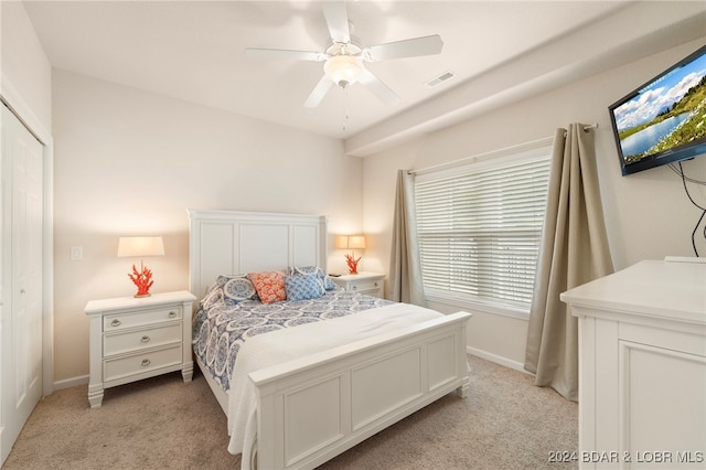 carpeted bedroom featuring ceiling fan and a closet